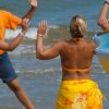 Persone ballano sulla spiaggia vicino al mare.